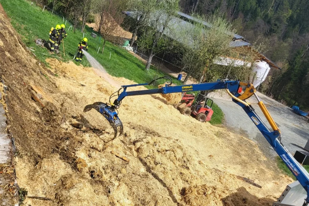 Ein Bild auf 5min.at zeigt, wie Feuerwehrleute brennende Strohballen löschen.