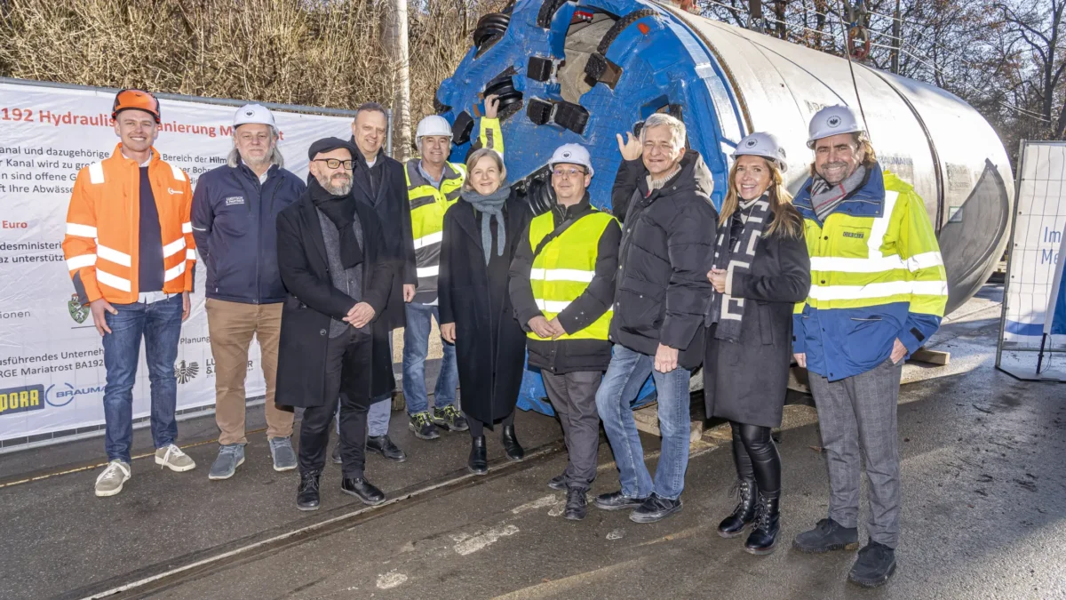 Foto auf 5min.at zeigt mehrere Personen in die Kamera lächeln.
