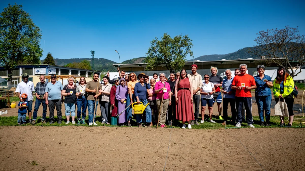 Ein Bild auf 5min.at zeigt eine Gruppe von Personen im Gemeinschaftsgarten.