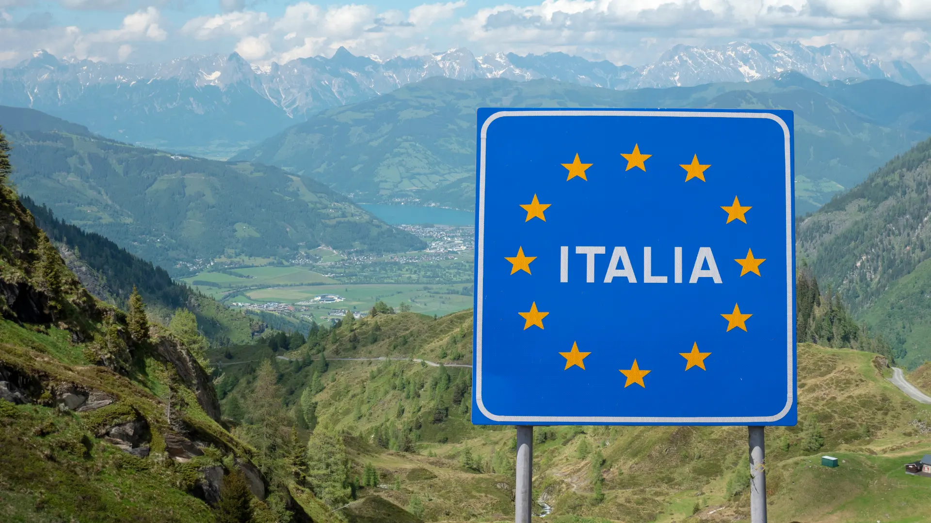 Das Bild auf 5min.at zeigt ein Gebirge und das Grenzschild von Italien